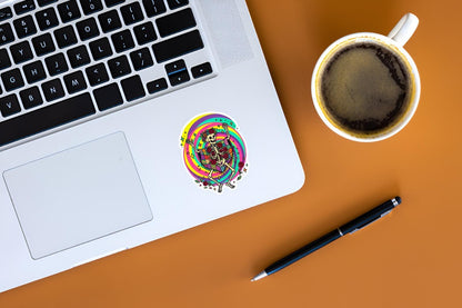 Laptop with colorful sticker, coffee cup, and pen on a brown surface