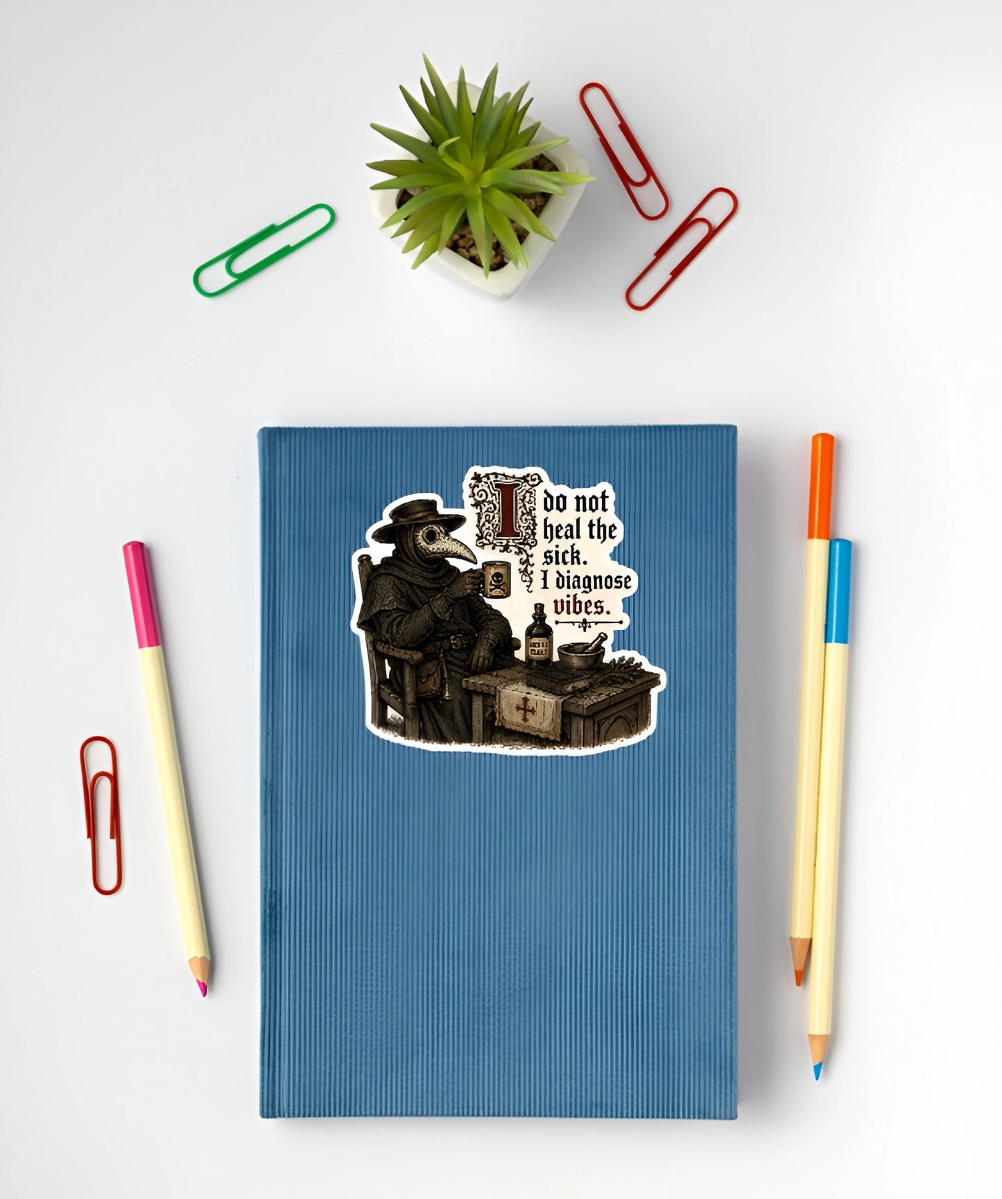 I Do Not Heal the Sick I Diagnose Vibes plague doctor sticker displayed on a blue notebook