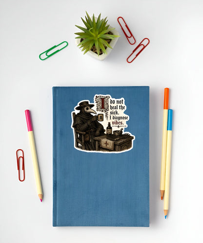 I Do Not Heal the Sick I Diagnose Vibes plague doctor sticker displayed on a blue notebook