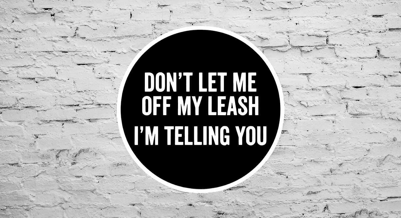 Black circular sticker with white text on a textured white brick wall background