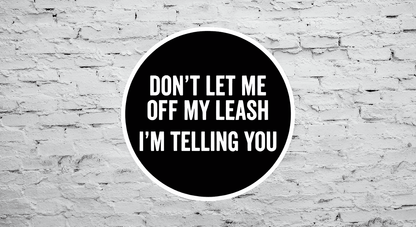 Black circular sticker with white text on a textured white brick wall background
