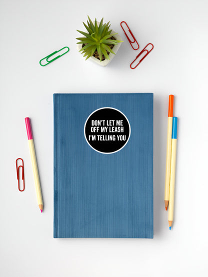 Blue notebook with a sticker on a white surface with stationery items