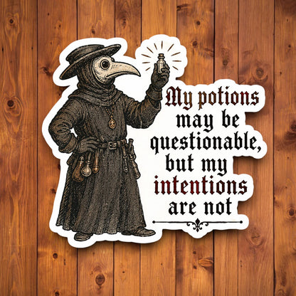 A die-cut sticker featuring a vintage plague doctor illustration and the text 'My potions may be questionable, but my intentions are not', shown against a brown wood plank background.