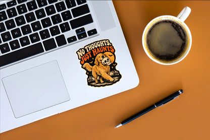 No Thoughts Just Haunts golden retriever Halloween sticker displayed on a silver laptop beside coffee