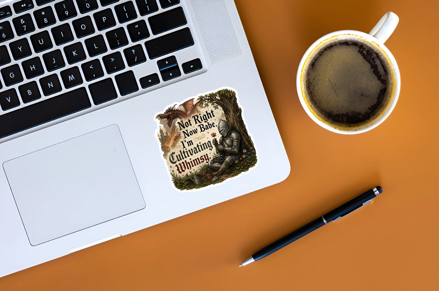 Not Right Now Babe I’m Cultivating Whimsy knight sticker displayed on a silver laptop beside coffee