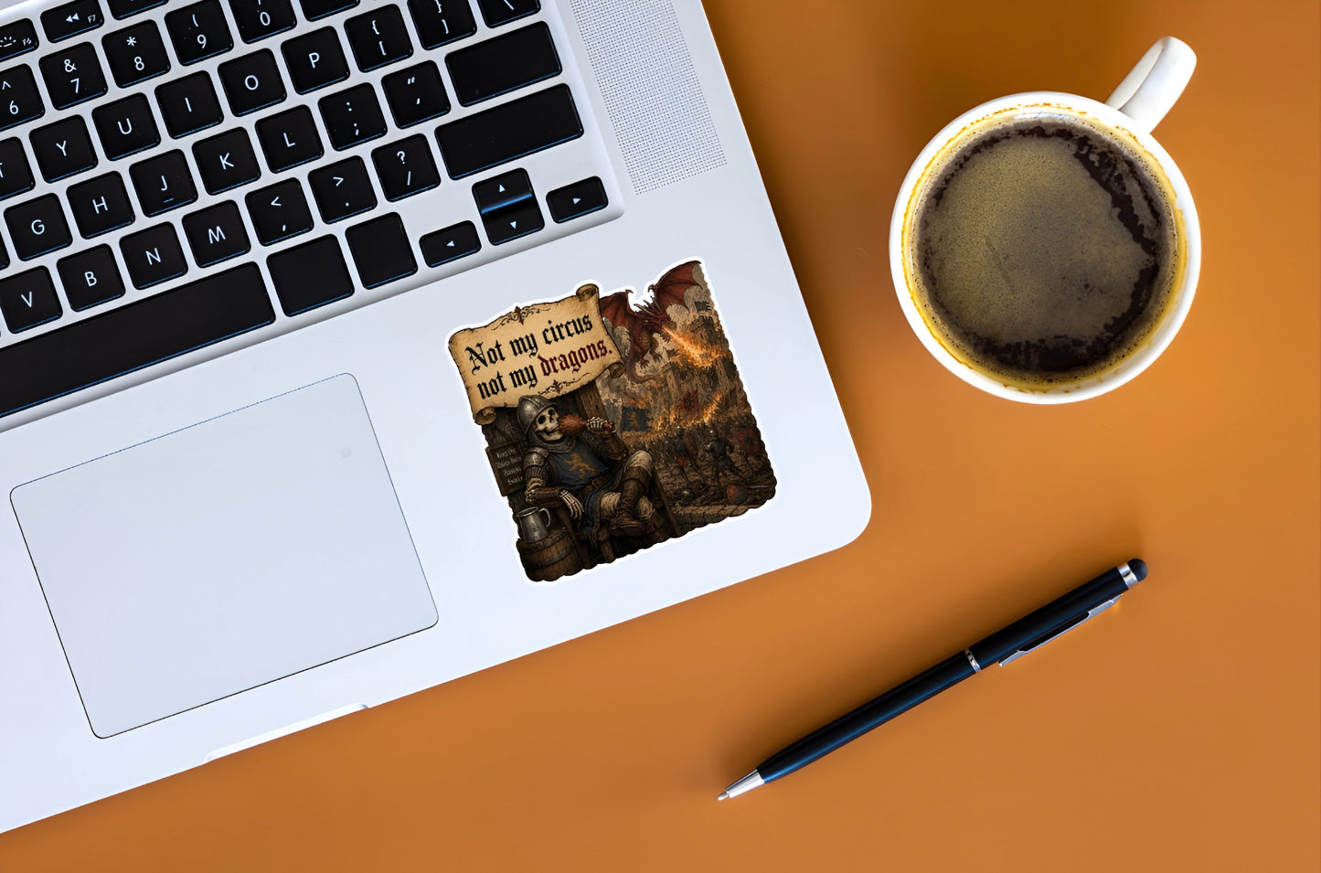 Not My Circus Not My Dragons skeleton knight sticker displayed on a silver laptop beside coffee
