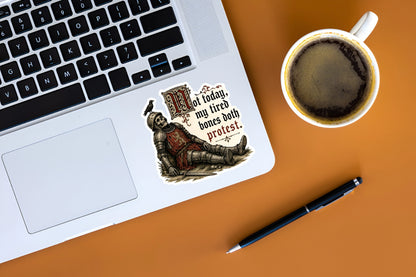 A die-cut sticker featuring a medieval knight in armor with the text 'not today, my fired bones both protest.' applied to the palm rest of a silver laptop.
