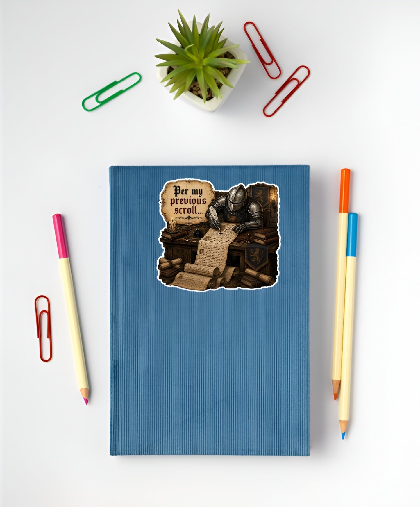 Funny Per My Previous Scroll medieval sticker displayed on a blue notebook