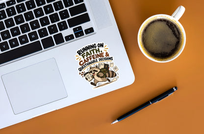 A laptop sticker with a cartoon raccoon and the text 'RUNNING ON FAITH, CAFFEINE & QUESTIONABLE DECISIONS' shown on a silver laptop. The scene is a styled flat-lay on an orange surface, next to a cup of coffee and a black pen.