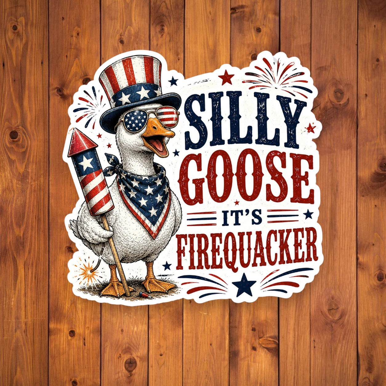 Sticker of a goose holding a firework with 'Silly Goose It's Firequacker' text on a wooden background