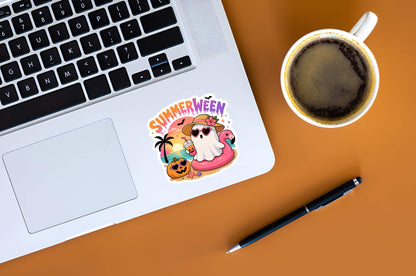 Laptop with a 'Summerween' sticker, cup of coffee, and pen on a brown surface