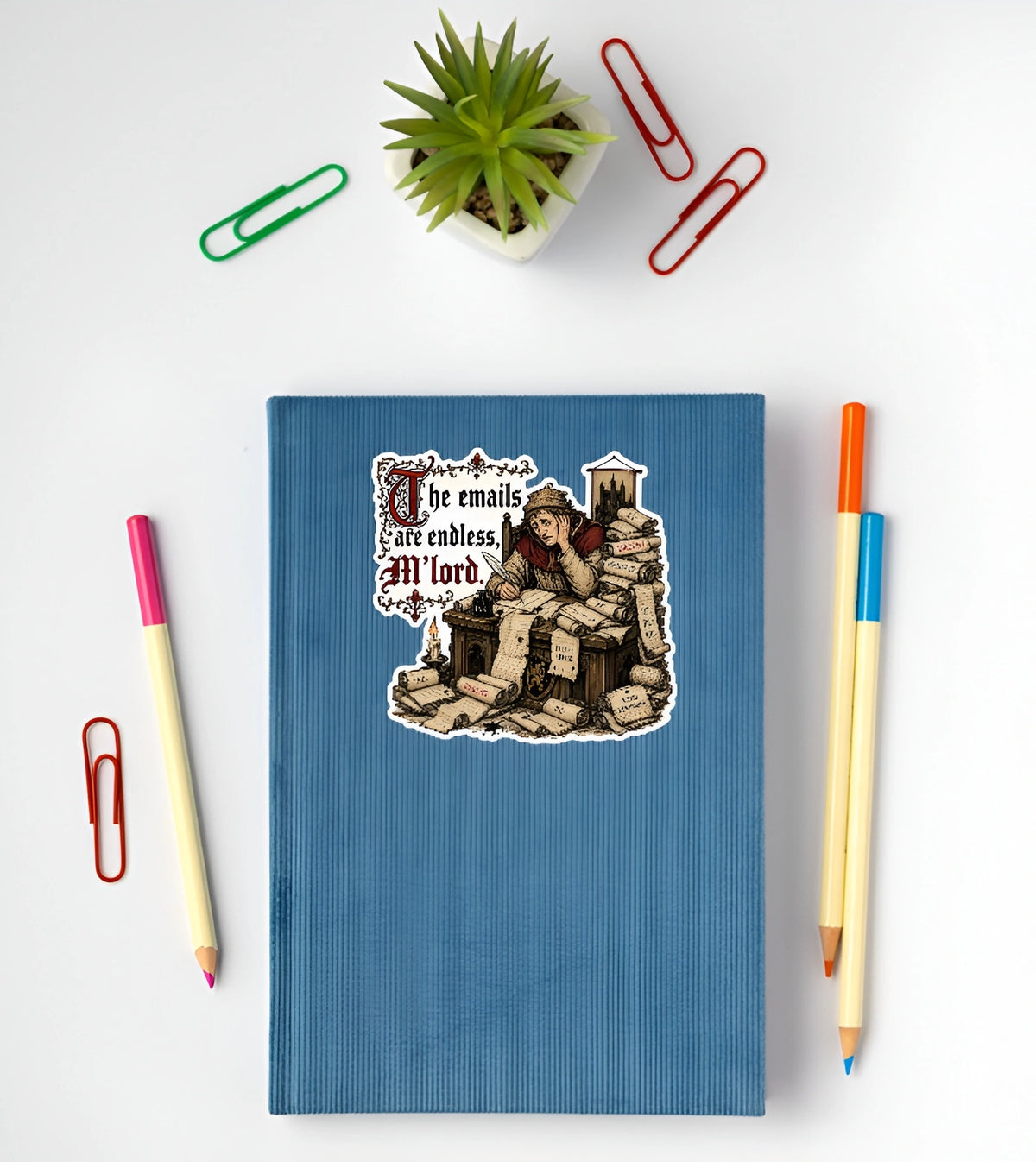 Funny medieval office sticker with endless emails quote displayed on a blue notebook