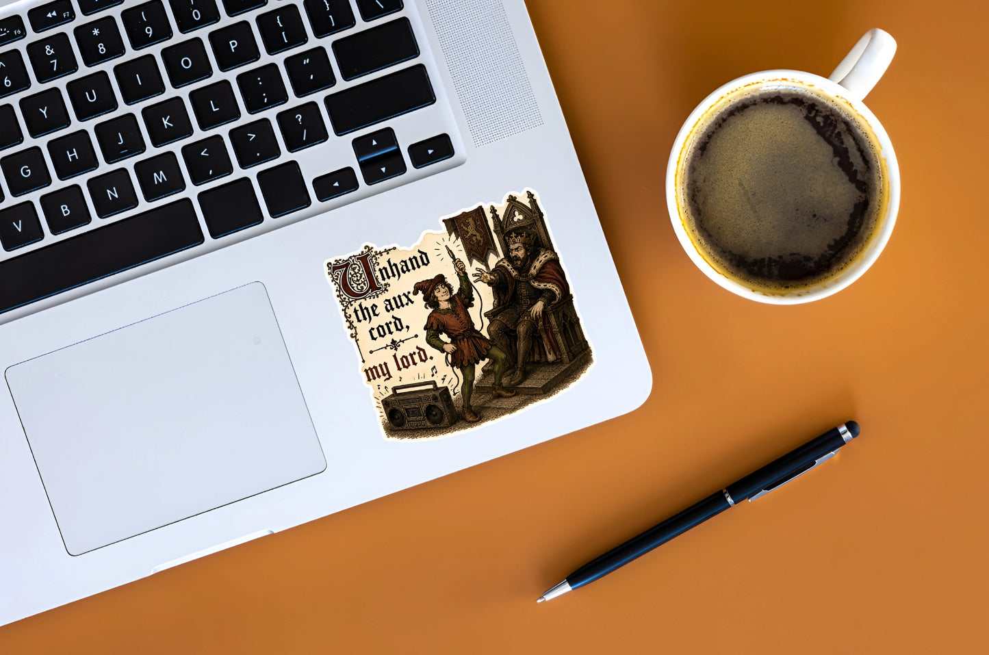 Funny medieval aux cord sticker displayed on a silver laptop beside coffee