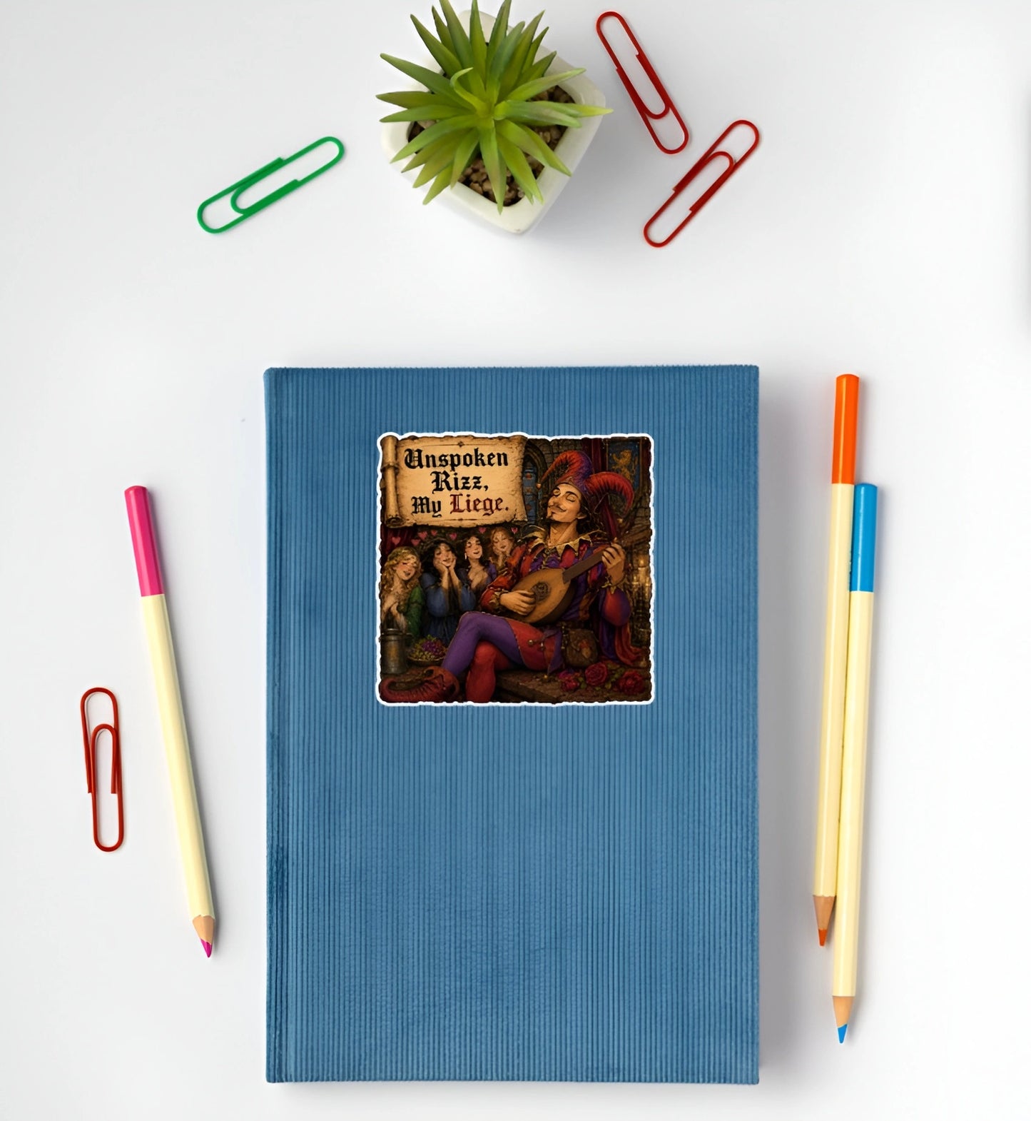 Funny Unspoken Rizz My Liege jester and bard sticker displayed on a blue notebook