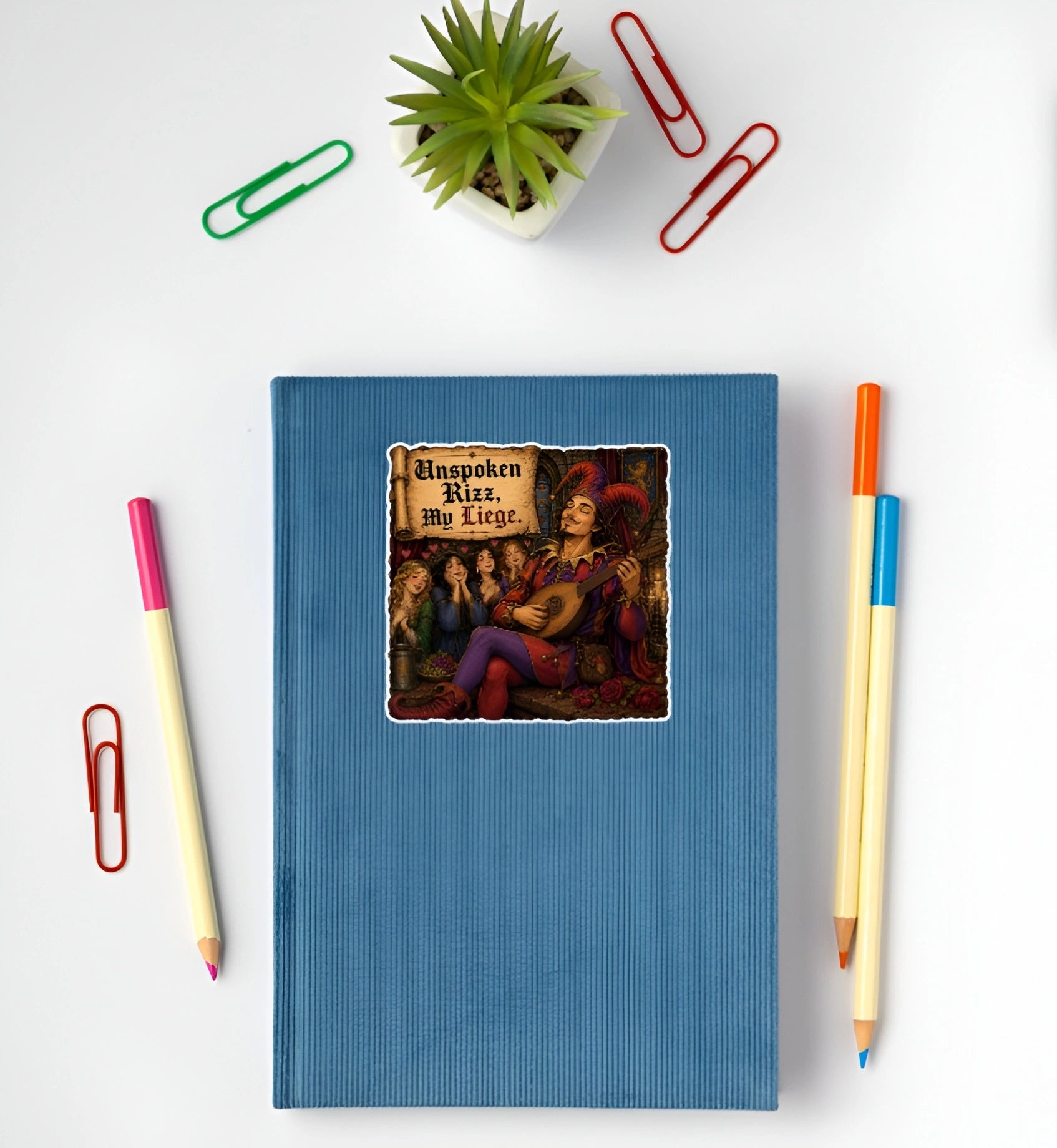 Funny Unspoken Rizz My Liege jester and bard sticker displayed on a blue notebook