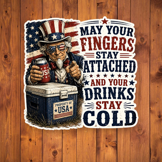 A flat, isolated vinyl sticker based on the file drinks stay cold with background.webp featuring a detailed vintage woodcut illustration of Uncle Sam wearing flag sunglasses, holding a USA beverage can next to a blue ice chest labeled "PROPERTY OF USA", alongside bold red and blue text reading "MAY YOUR FINGERS STAY ATTACHED AND YOUR DRINKS STAY COLD".