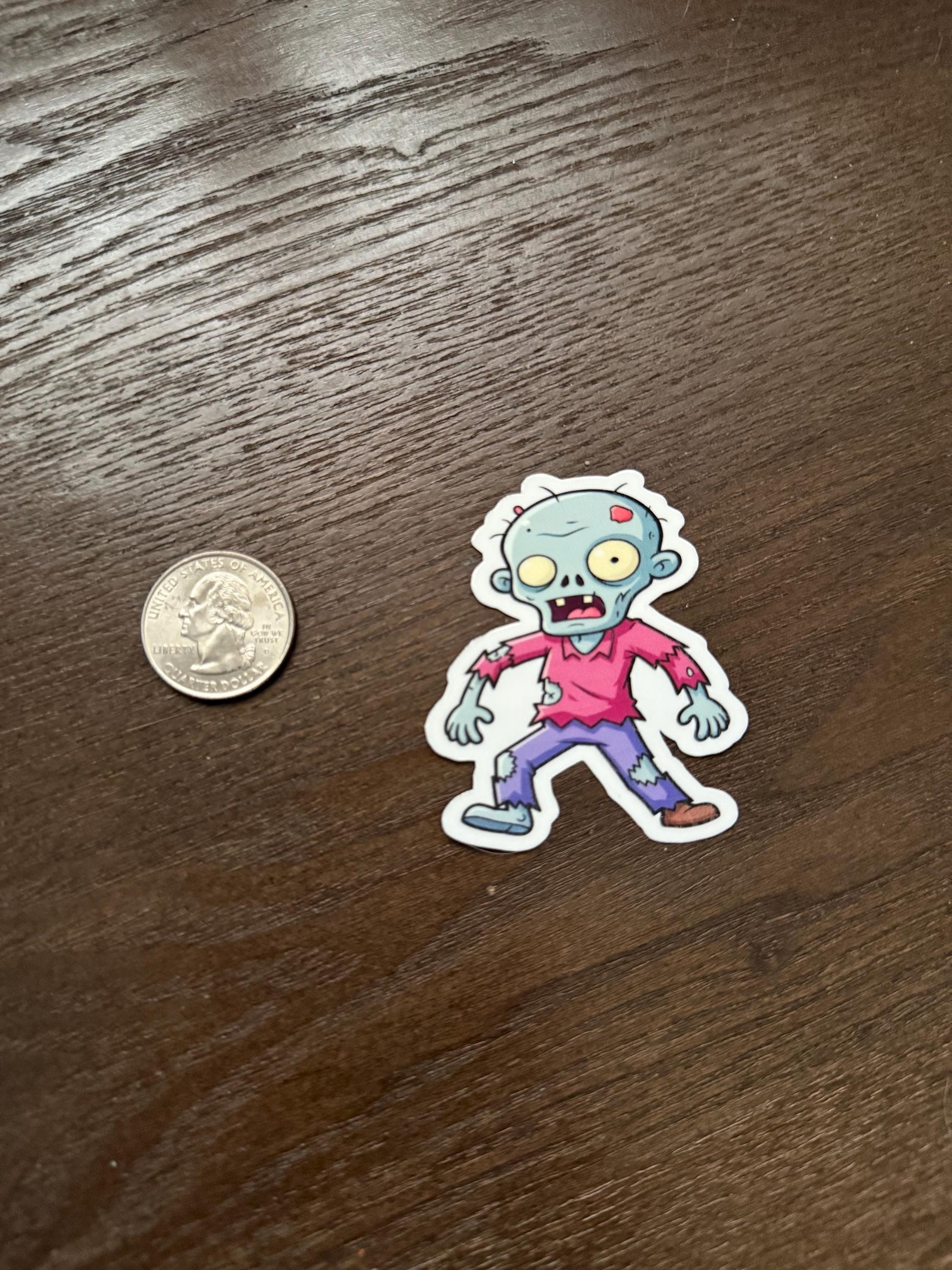 Cartoon zombie sticker next to a quarter on a wooden surface