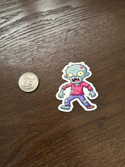 Cartoon zombie sticker next to a quarter on a wooden surface