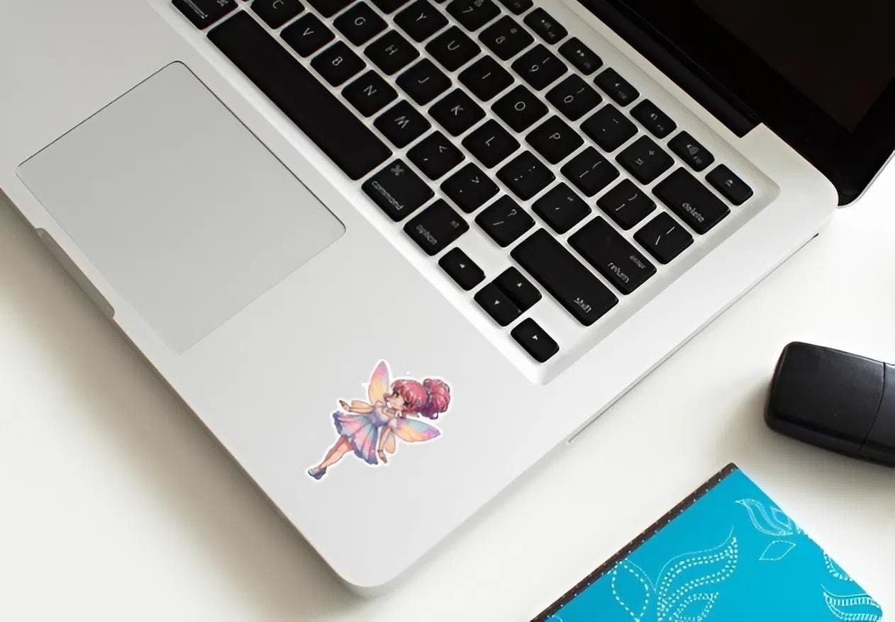 Laptop with a colorful fairy sticker on a desk