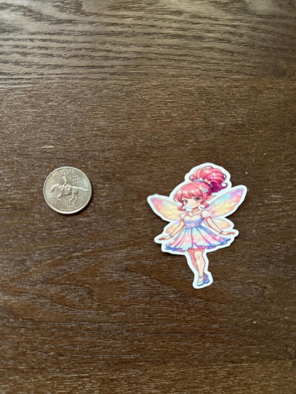 Sticker of a colorful fairy character next to a quarter on a wooden surface
