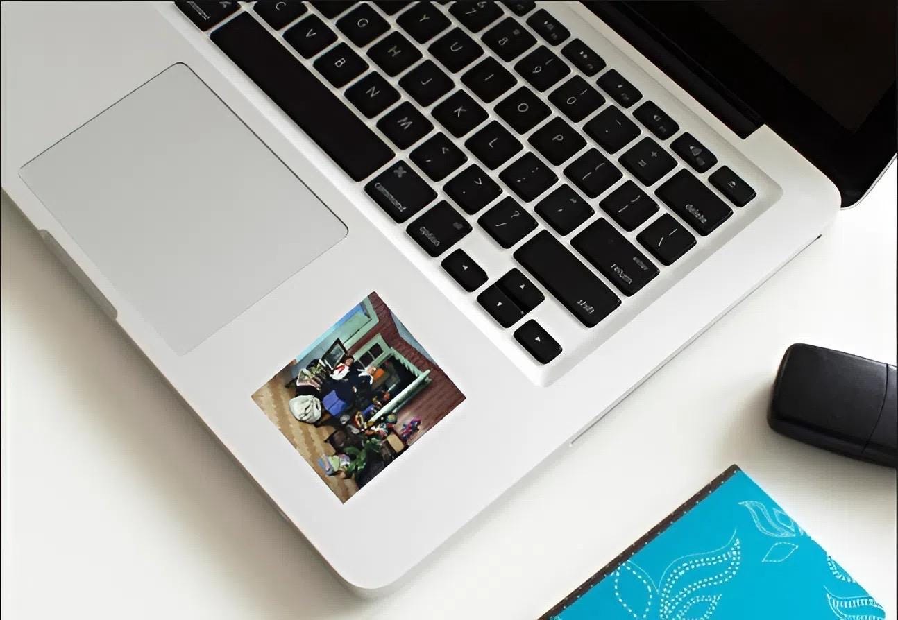 Laptop with a screen displaying a video call on a white surface