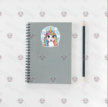 Gray notebook with a unicorn sticker and a pencil on a white background with brand logos.