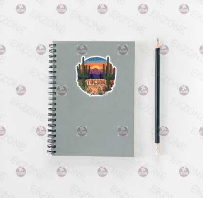 Gray spiral-bound notebook with a desert-themed sticker and a pencil on a white background.