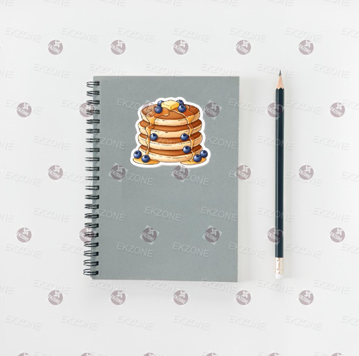 Notebook with a stack of pancakes sticker and a pencil on a white background