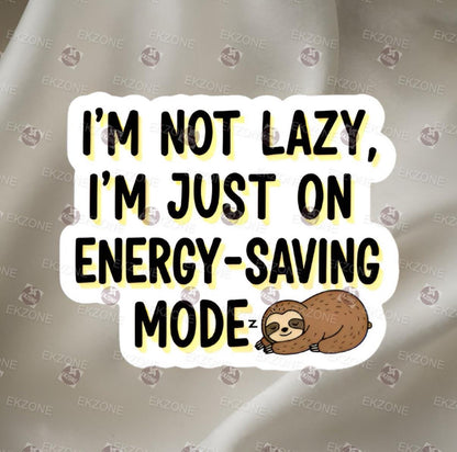 A flat, isolated vinyl sticker featuring a funny cartoon illustration of a cute, sleepy sloth hanging lazily from a tree branch alongside the sarcastic text "I'm Not Lazy, I'm On Energy Saving Mode".