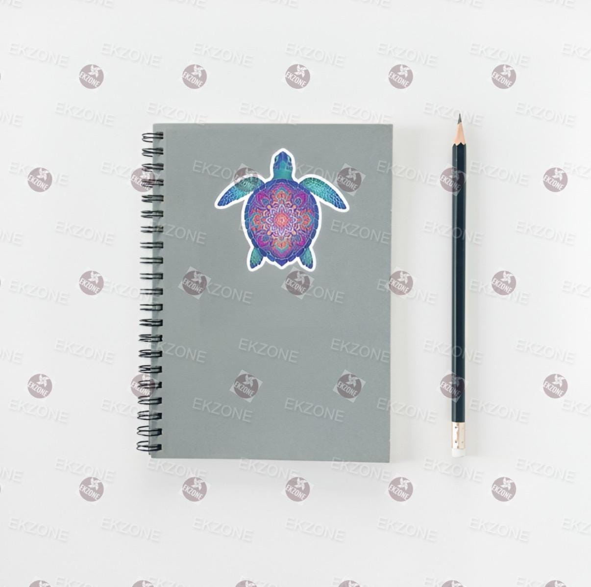 Notebook with a turtle design sticker and a pencil on a white background 