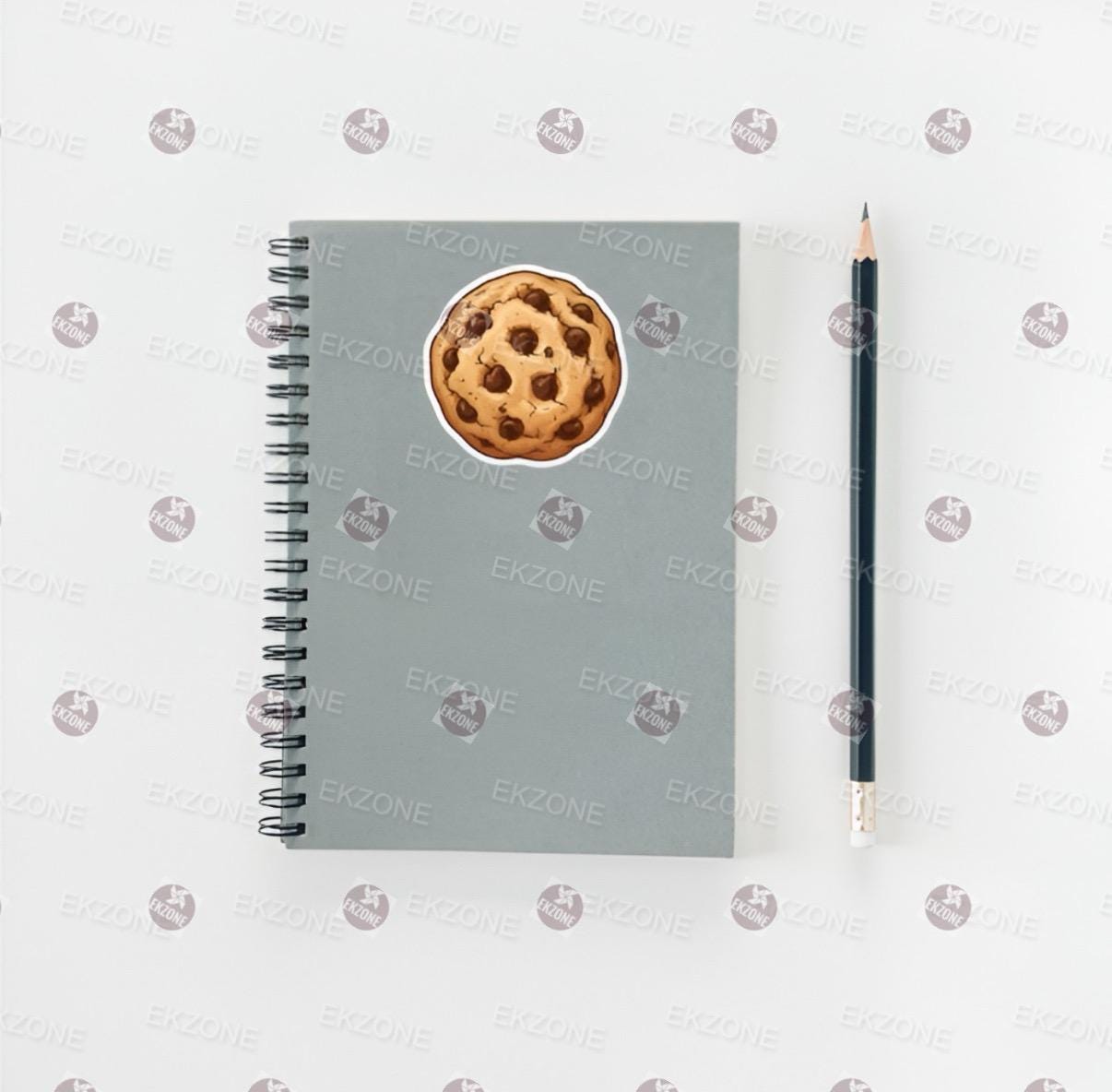 Gray notebook with a cookie design on the cover, next to a pencil on a white background.