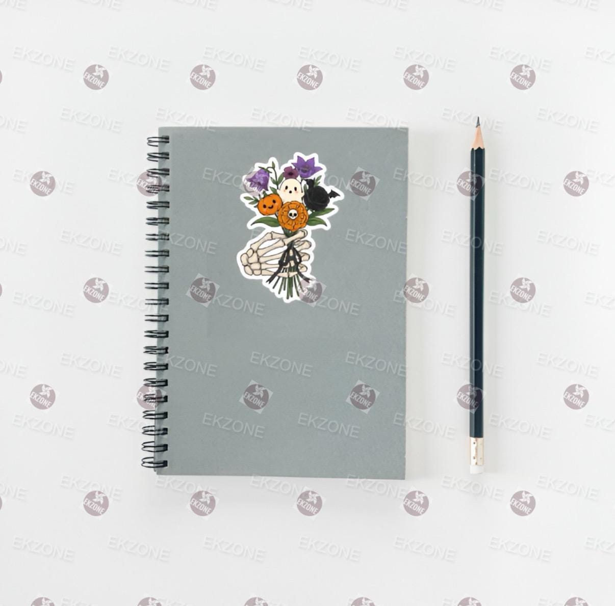 Notebook with decorative stickers and a pencil on a white background
