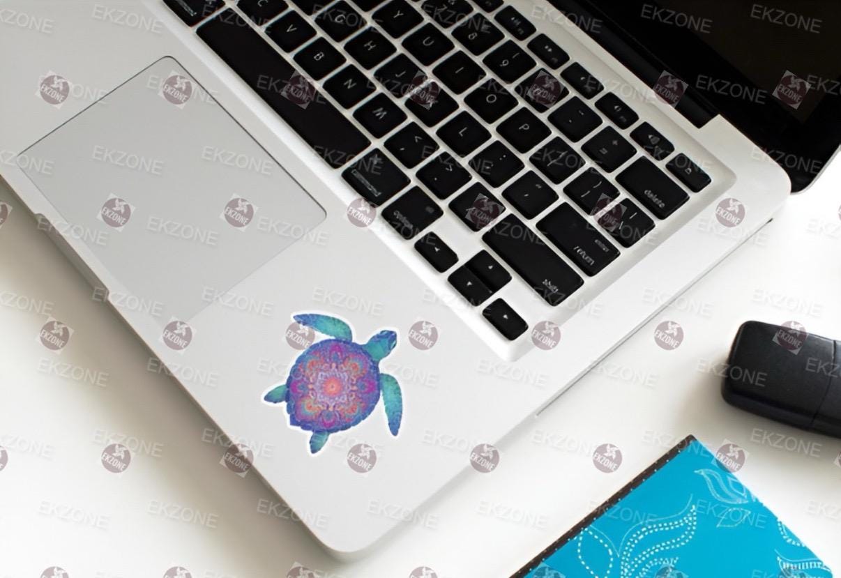 Laptop with a colorful turtle decal on a white surface