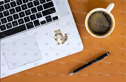 Laptop with raccoon sticker, coffee cup, and pen on a brown surface with 'Funny Label' branding.