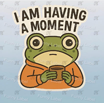 Cartoon frog holding a mug with 'I AM HAVING A MOMENT' text on a light blue background.
