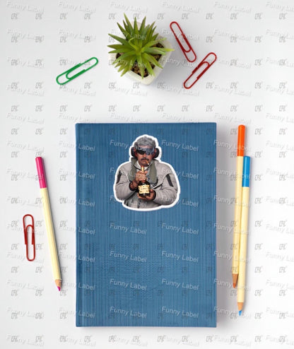 Blue notebook with a sticker of a person on a white surface with stationery items.