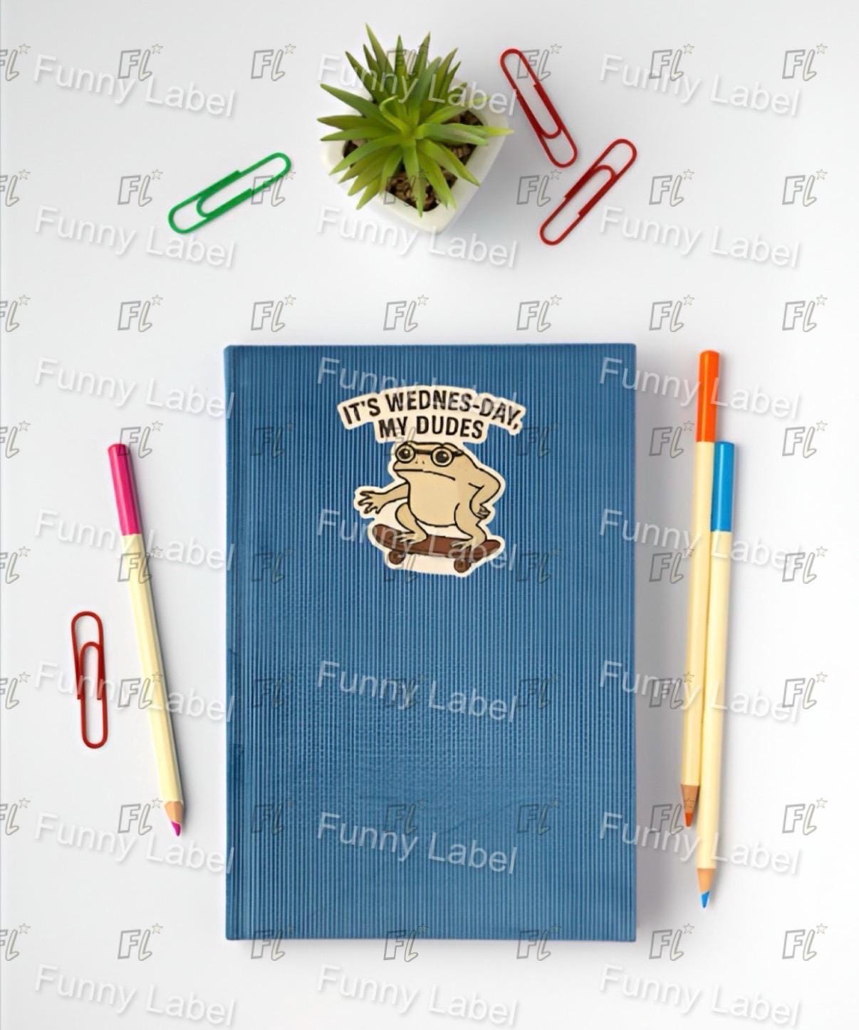 Blue notebook with a sticker on a white surface with stationery items