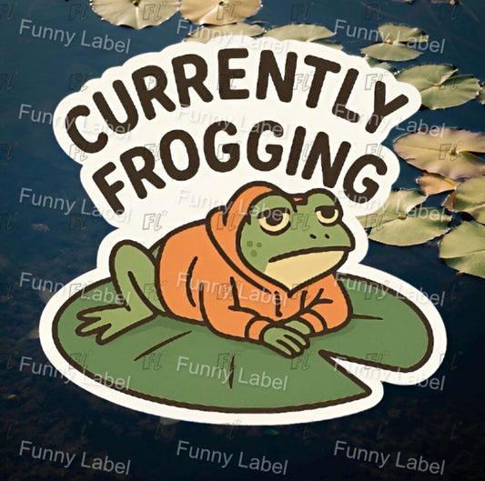 Sticker with a frog and 'Currently Frogging' text on a dark background with leaves.