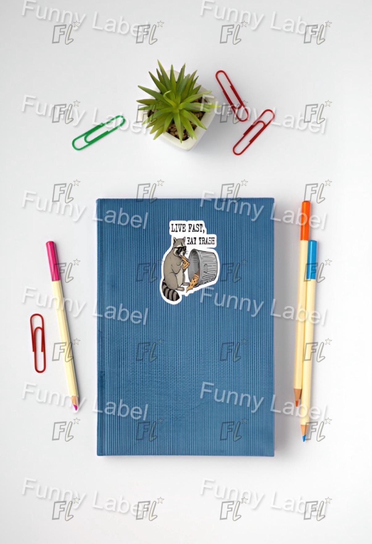 Blue notebook with a sticker, pens, and paper clips on a white surface
