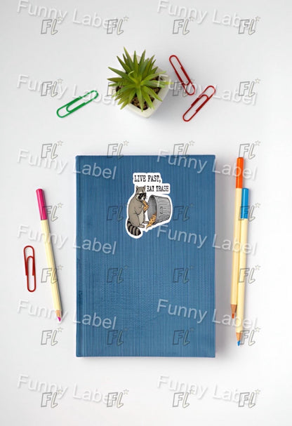 Blue notebook with a sticker, pens, and paper clips on a white surface