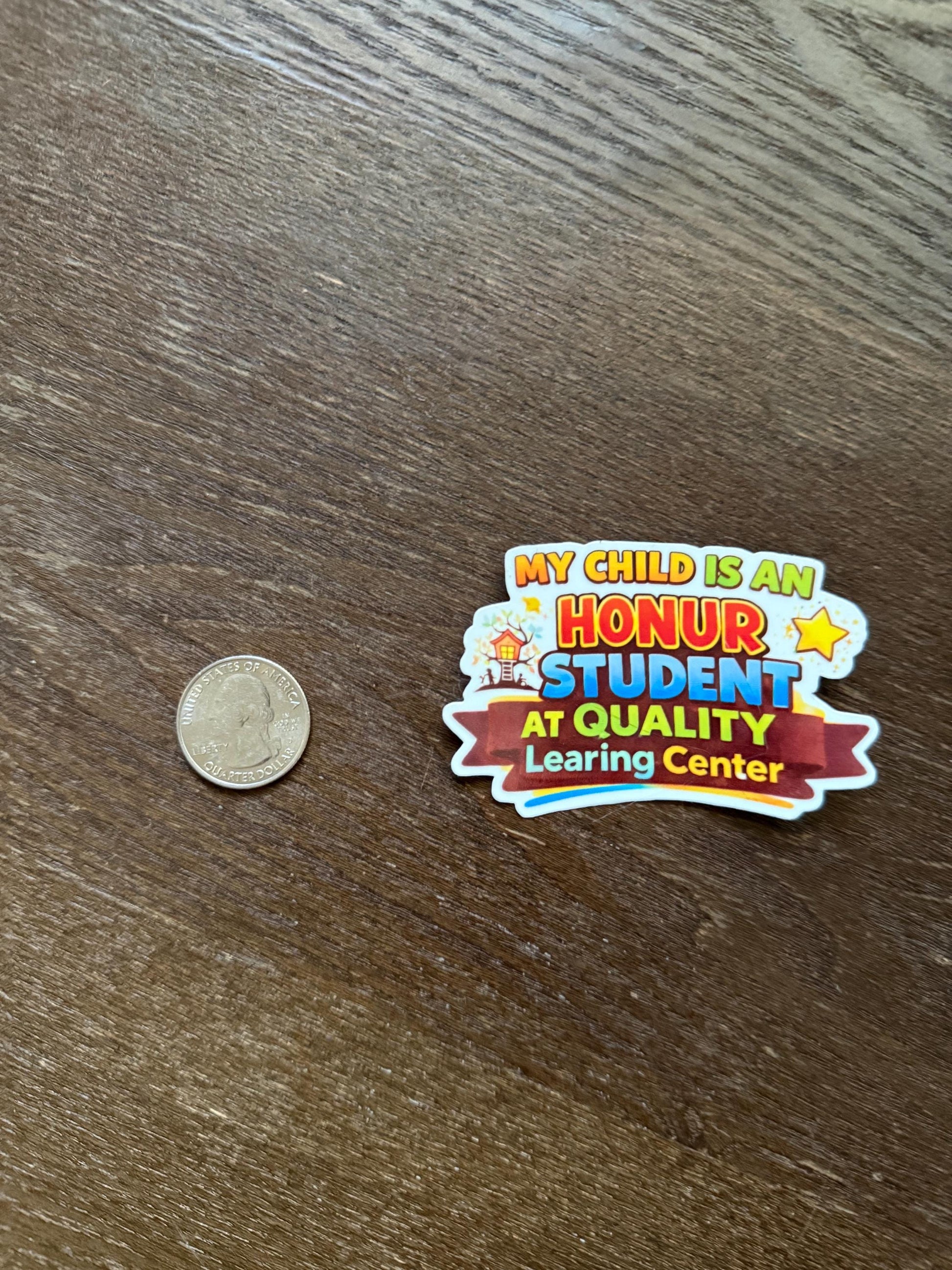 Colorful sticker on a wooden surface with a coin for scale