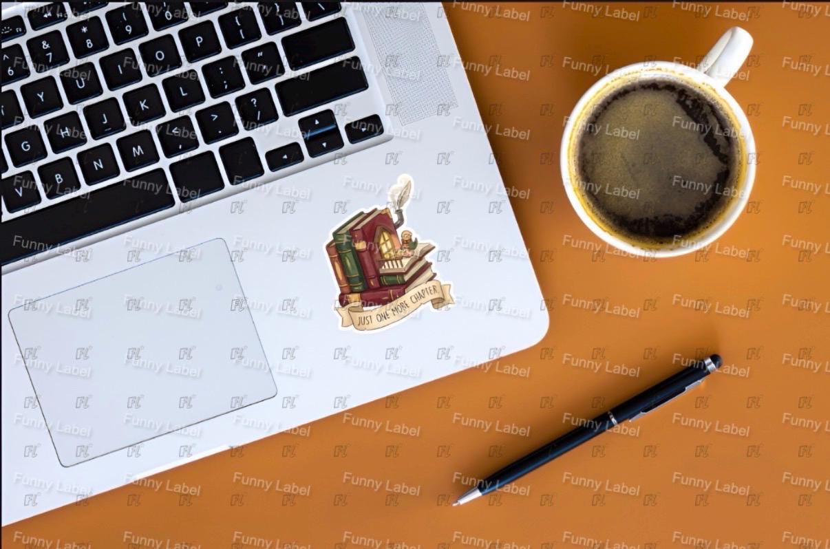 Laptop with a logo on a brown surface next to a coffee cup and pen.