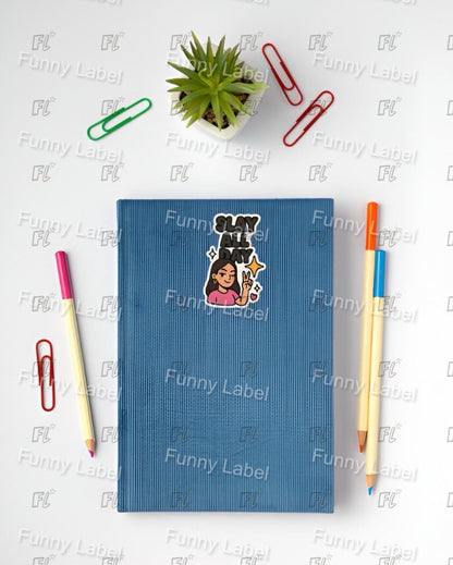 Blue notebook with a sticker of a person with a dog on a white surface with stationery items.